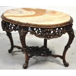 An ornate marble topped Italian carved walnut occasional table, the shaped inset top above foliate