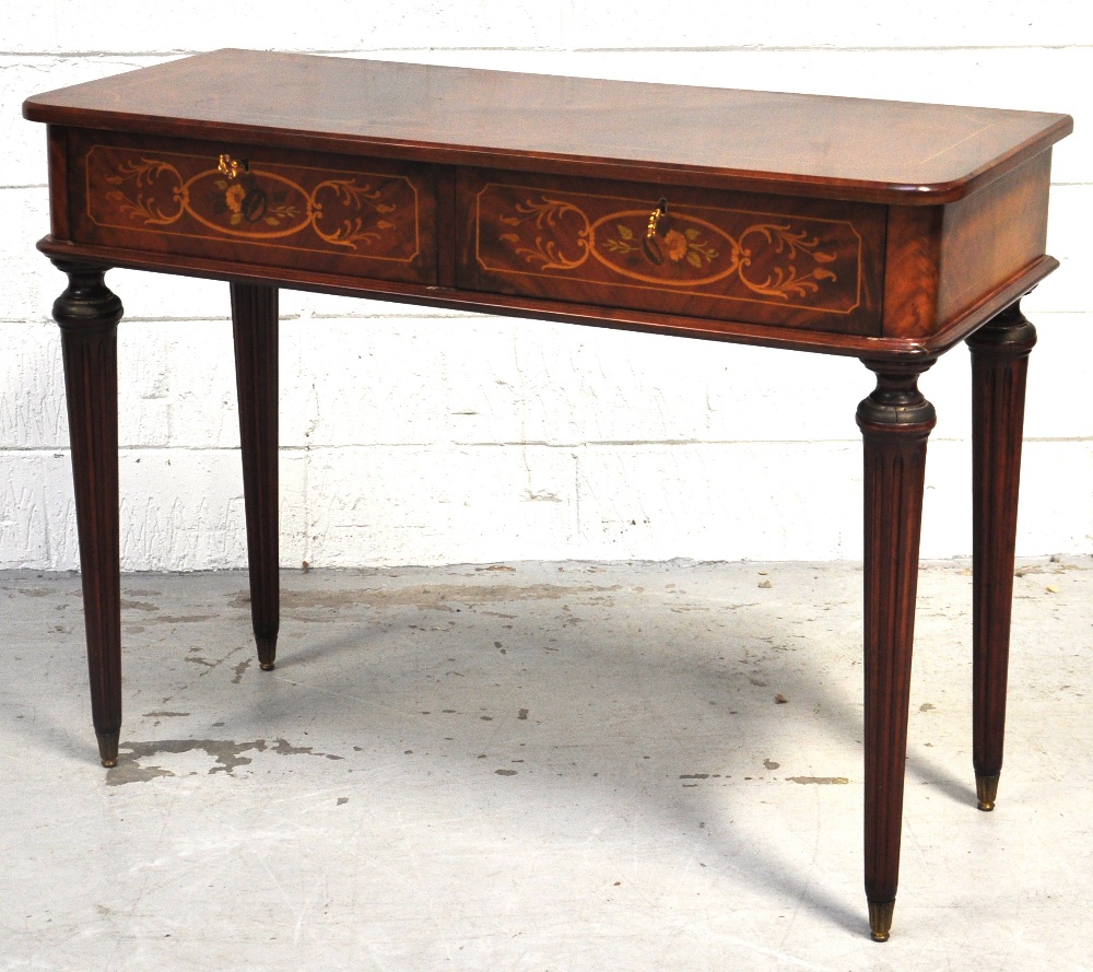 A reproduction inlaid two drawer side table raised on fluted tapering turned legs, width 104cm.