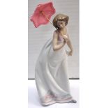 A signed Lladro piece of a young girl with a parasol.