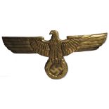 A gilt painted eagle surmounted swastika plaque, a prop from the film "Captain America", width 65cm