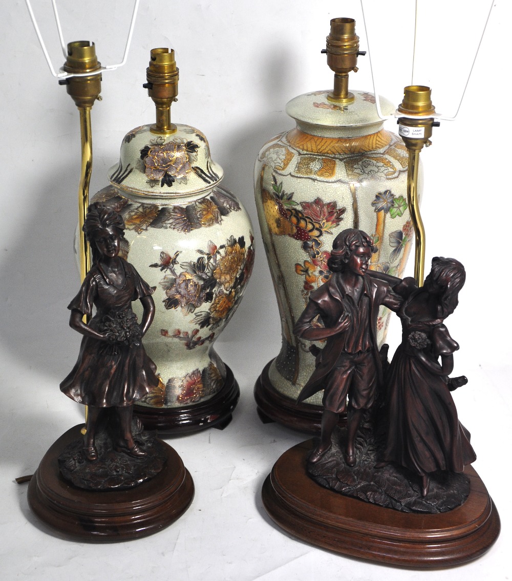 Two modern bronzed and wooden table lamps one in the form of a young courting couple and the other