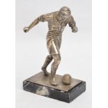 A metal trophy figure of an early 20th century footballer, mounted on rectangular marble plinth,