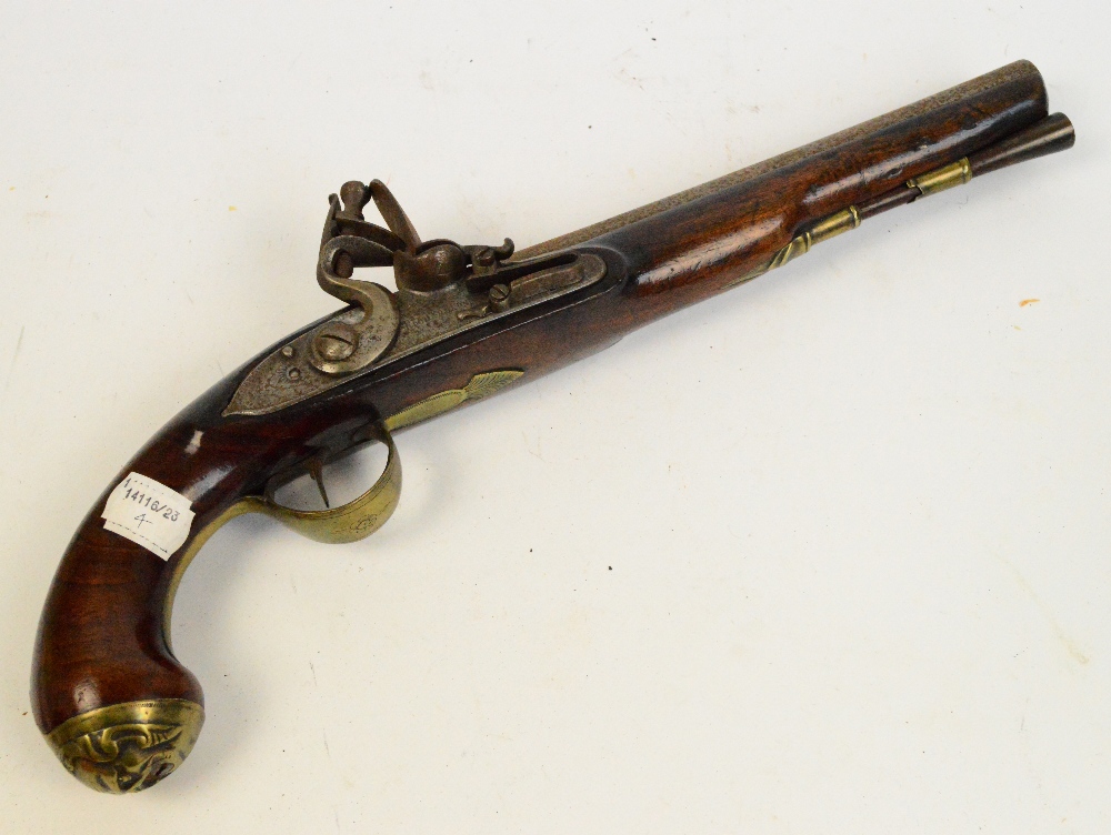 A late 18th century flintlock pistol with walnut stock and brass furniture, and face mask to the