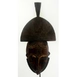 A Yaure mask, Ivory Coast, with incised decorated upper section and face retaining pigmentations,