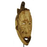 An Igbo spirit mask, Nigeria, with raised coiffeur, pigmentation to face and open mouth,