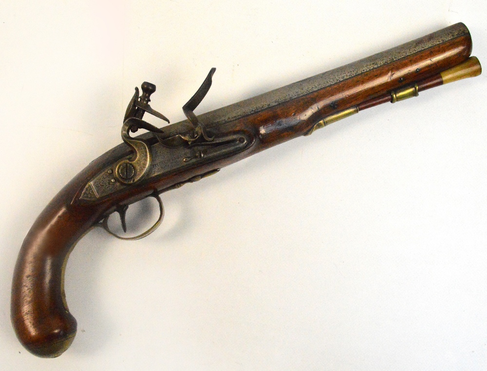 A late 18th century flintlock pistol with walnut stock, brass furniture and with side plate engraved