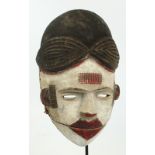 An Ogoni spirit mask, Nigeria, with articulated mouth, red pigmentation and kaolin,