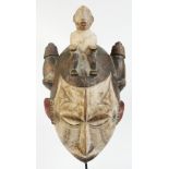 An Idoma funerary mask, Nigeria, with seated figure to the coiffeur,