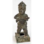 A 17th century Benin bronze figure of a Portuguese soldier holding a gun and raised on square