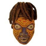 A Bamileke bead decorated mask, Cameroon, with colourful decoration to the face,