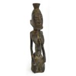 A Dogon kneeling female figure, Mali, modelled with raised coiffeur, lip plug and conical breasts,