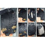 A black trunk containing a large quantity of naval uniforms including overcoat, evening mess dress,