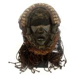 A Dan mask, Ivory Cast, the top section set with cowry shells, braided fibre hair,