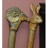 Two Cumbrian Collection "Handcrafted" thumbsticks, one carved with a hare, the other with a ram,