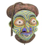 A Bamileke beaded mask, Cameroon, with rope adorned upper section and brightly decoration face,