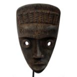 A Dan Bagle mask, Ivory Coast, with raised "horn" decoration to the forehead and tubular eyes,