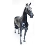 A decorative fibreglass life size model of a horse standing four square.