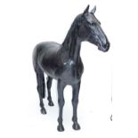 A decorative fibreglass life size model of a horse standing four square.