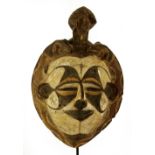 An Igbo spirit mask, Nigeria, with animal surmount and snakes to the border,