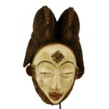 A Punu-Lumbo Okuyi mask, Gabon, with elaborate coiffeur,