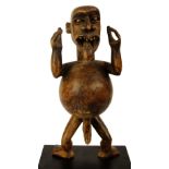 An Ibibio warning figure, Nigeria, modelled as a gent with protruding tongue,