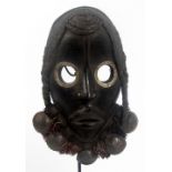 A Dan child's mask, Ivory coast, with plaited fibre hair,
