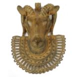 An 18th century Benin bronze rams head plaque with pierced frame to the chin, length 27cm.