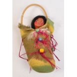 A Native American Skookum doll in bead adorned papoose, height 29cm.