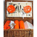 A vintage wicker picnic hamper complete with cups, saucer etc.