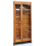 A large 20th century light oak and glazed double door display cabinet with interior glass shelves,