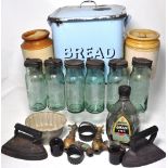 A quantity of kitchenalia to include a blue enamel bread bin, flat irons,