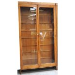 A large 20th century light oak and glazed double door display cabinet with interior glass shelves,