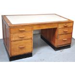 An early 20th century pale oak office desk with three drawers to either side and one central drawer,