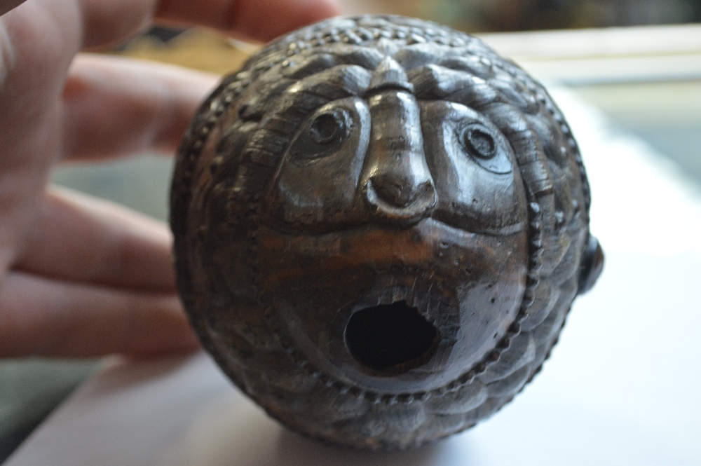 An unusual carved coconut with mask detail to the front and band of scrolling decoration with - Image 2 of 6