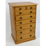 A small eight drawer pine collector's cabinet with two drawers above six graduated drawers,