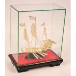 A decorative 20th century Chinese white metal model of a three sail junk on carved hardwood base,