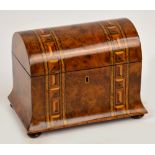 A Victorian walnut and strap bound inlaid decorated dome topped two division tea caddy raised on