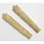 Two Chinese Canton carved ivory cylindrical needle cases decorated with figures and pine trees,