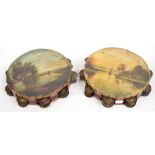 A pair of late 19th century tambourines painted with riverside scenes, diameter of each 25cm.