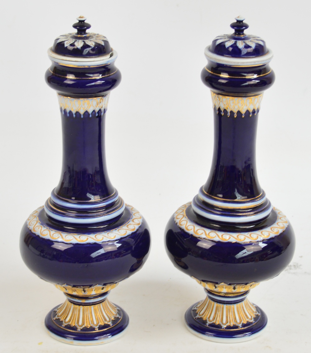 A pair of late 19th/early 20th century Meissen vases and covers, each gilt heightened on a cobalt