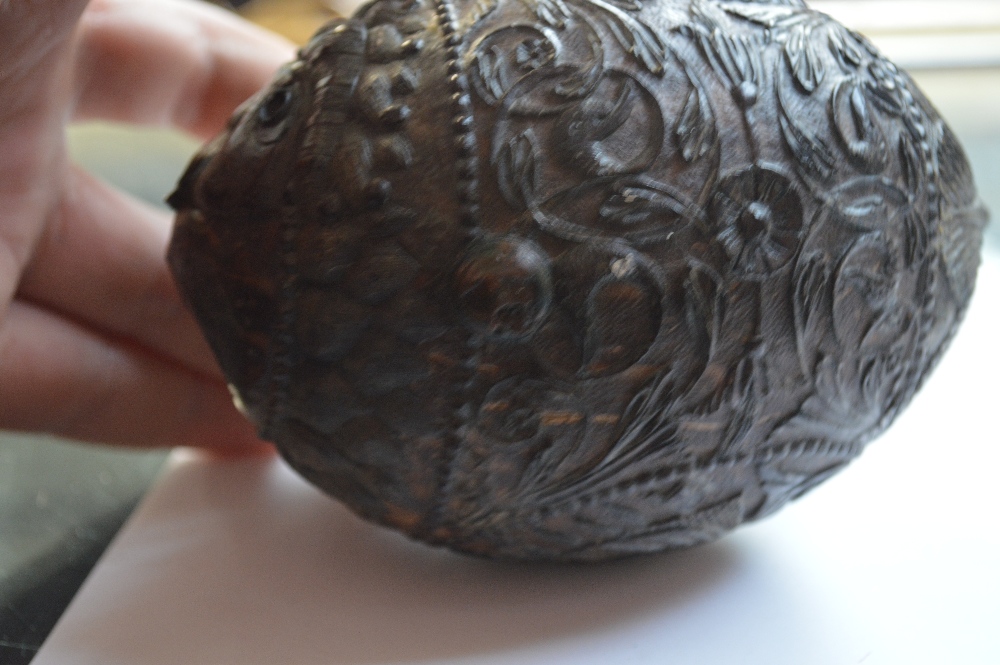 An unusual carved coconut with mask detail to the front and band of scrolling decoration with - Image 3 of 6