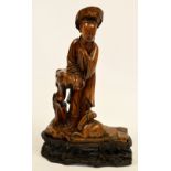 A 19th century Chinese hardwood carving of a woman standing by a recumbent ram, on carved and