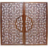 A pair of early 20th century Chinese pierced rectangular window panels centred with a circular shou