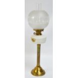 A brass oil lamp with etched globular shade, opaque reservoir and fluted central column,