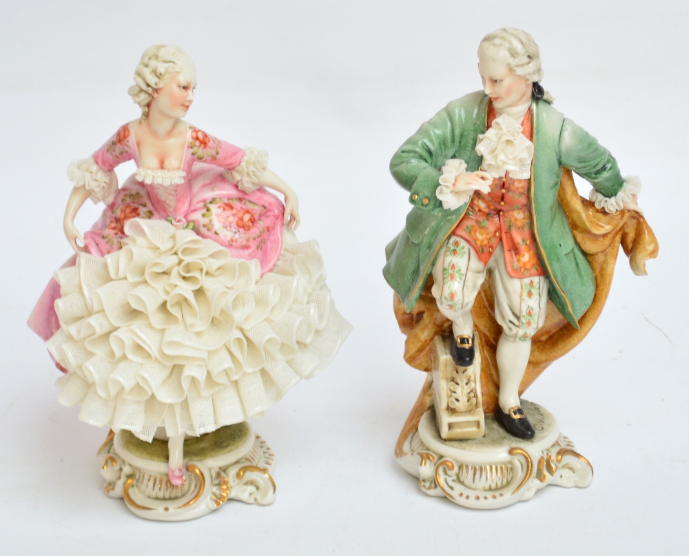 A pair of 1950s Capodimonte figures of male and female dancers, in lace embellished clothing on