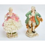 A pair of 1950s Capodimonte figures of male and female dancers, in lace embellished clothing on