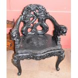 A decorative carved Chinese elbow chair.