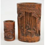 An early 20th century Chinese bamboo brush pot carved with figures amongst bamboo and pine trees,