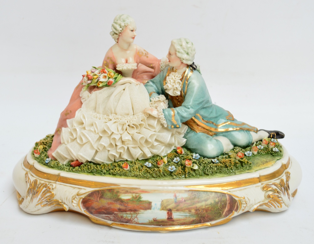 A 1950s Capodimonte figure group of two lovers with lace embellished clothing, on a plinth, signed