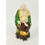 A 19th century Chinese biscuit Sancai glazed figure of a seated Budai holding a string of beads,